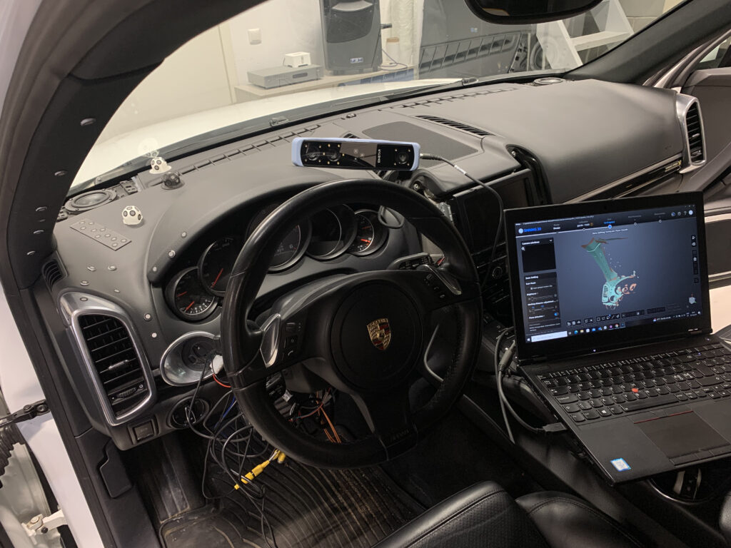 Porsche Cayenne’i armatuurlaua 3D-skaneerimine, skanner armatuurlaual ja skaneering sülearvuti ekraanil.