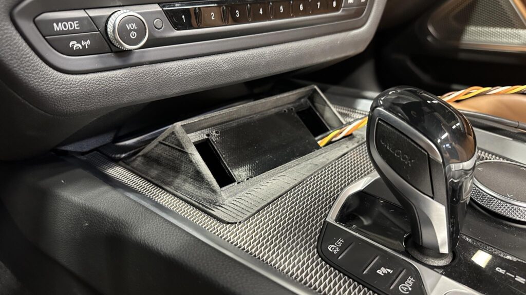 3D-prinditud adapter BMW Z4 keskkonsoolis Helix Director’i paigaldamiseks tuhatoosi asemele.