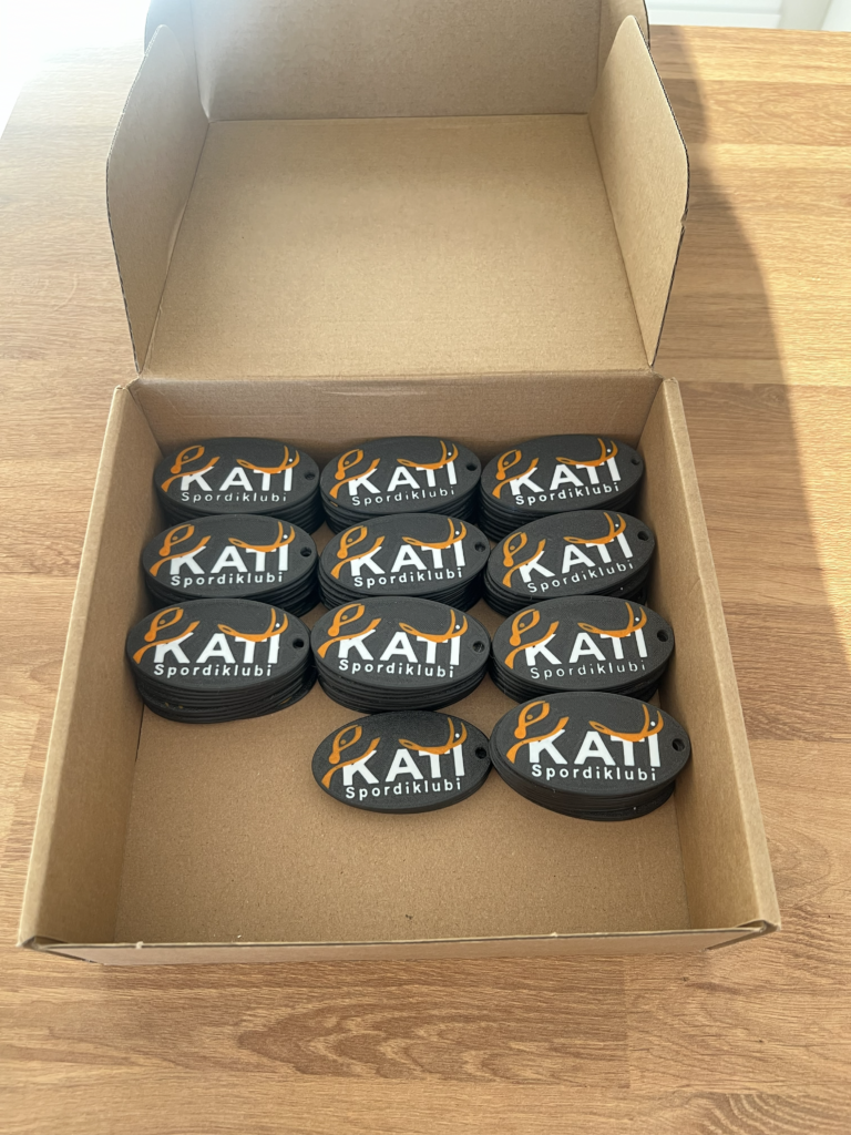 Karbis Kati spordiklubi logoga mitmevärvilised 3D-prinditud võtmehoidjad.