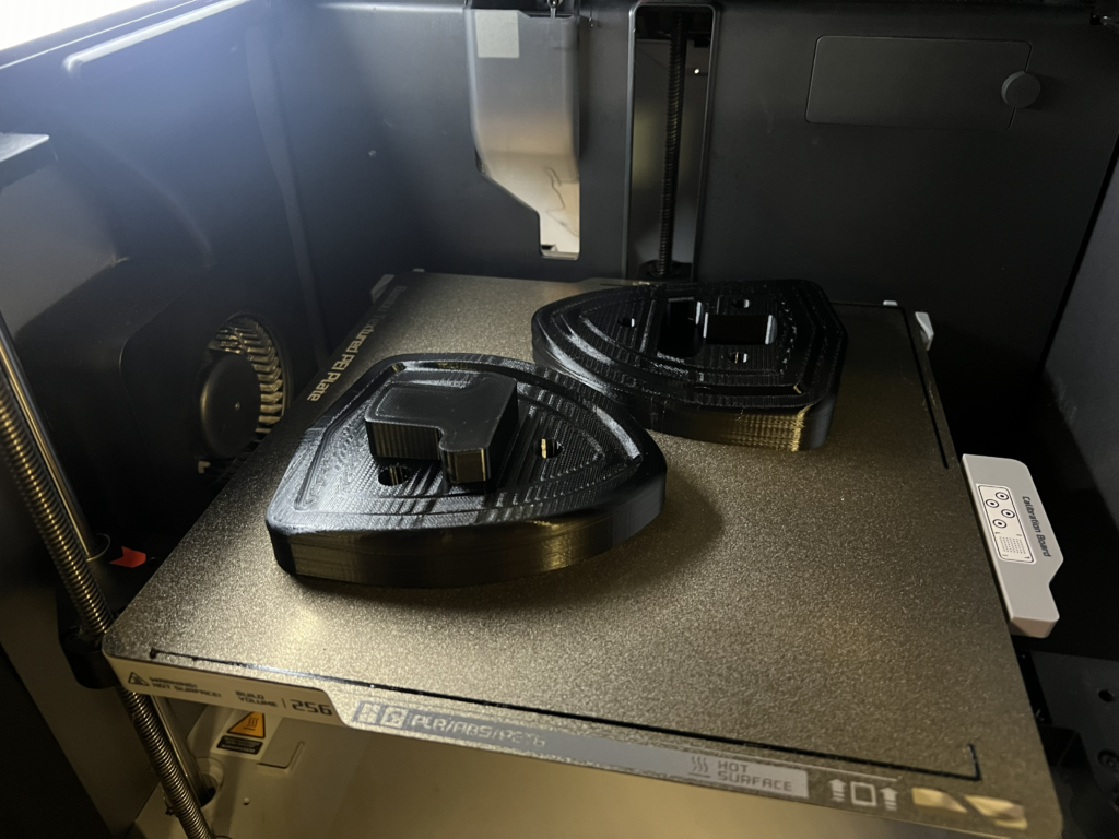 3D-prinditud vormid Porsche tiiva embleemi süvise pressimiseks 3D-printeri ehitusplaadil.